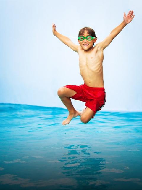 Two kids jumping in a pool outdoors