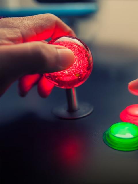 Male hand playing arcade machine