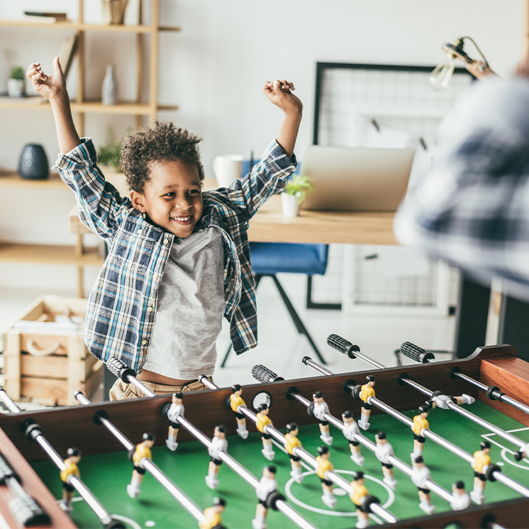 Young kid excited while playing foosball
