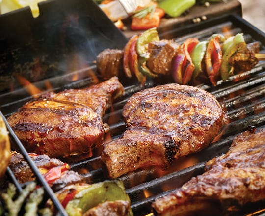 Food cooking on a grill with lid open 