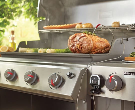 Food cooking on a grill with lid open 