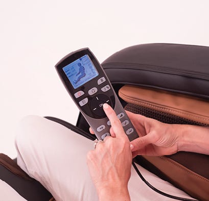 Closeup of person sitting in a massage chair using the controller to select massage option.