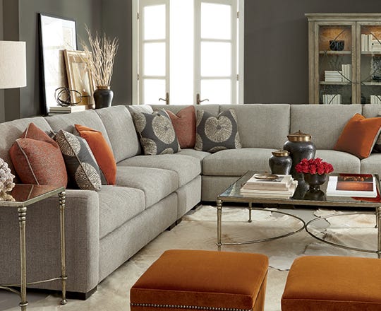 Transitionally styled sofa in beige color in a living room with colorful home accents throughout 