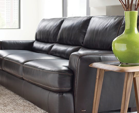 Angled view of a contemporary brown leather sofa in a living room
