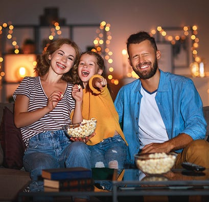 Family watching a movie eating popcorn