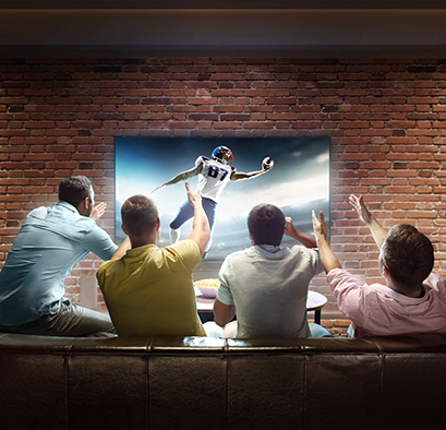 Men watching a football game on tv cheering excitedly