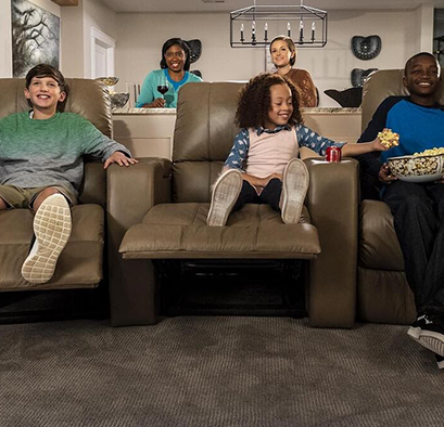 Kids relaxing in home theater chairs and eating popcorn