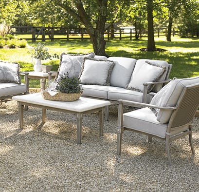 Outdoor seating set with cocktail table on a sunny outdoor patio in backyard