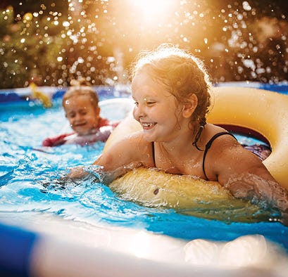 Family in pool with daughter floating on a tube