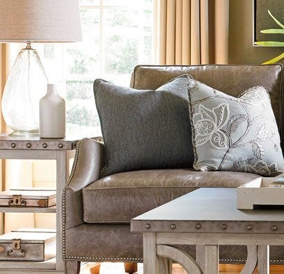 Grey leather sofa with pillows, end table and lamp