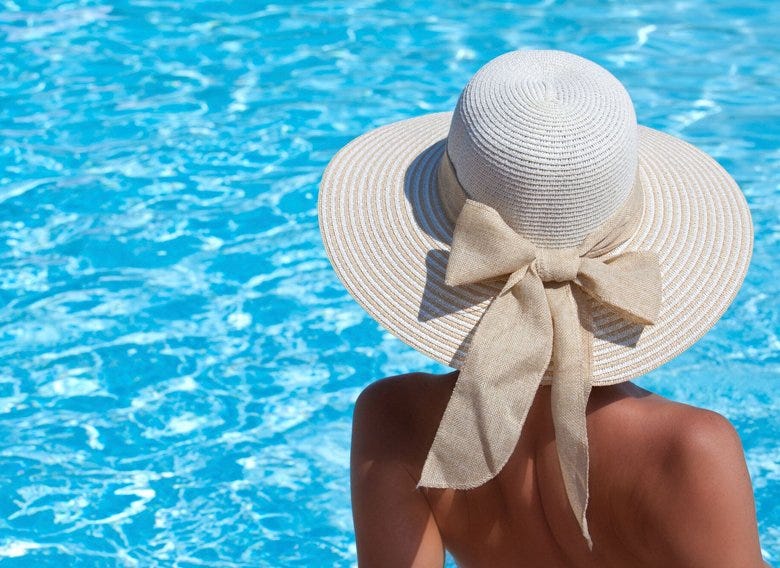 Woman wearing a hat beside a pool